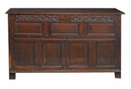 A Charles II oak mule chest, circa 1660, with hinged lid above decorative carved frieze and an