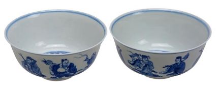 A pair of Chinese blue and white bowls decorated with the Eight Immortals amid a landscape setting,