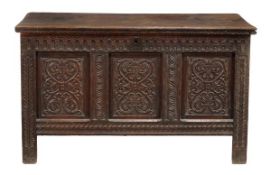 A Charles II oak coffer circa 1680 with a moulded lid above an arcaded frieze and triple panel