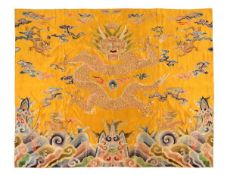 A large Chinese silk hanging of a four-clawed dragon in pursuit of a flaming pearl, embroidered