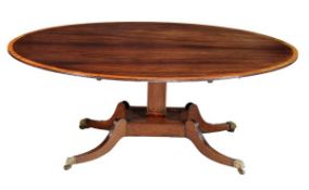 A Regency satinwood banded mahogany dining table, circa 1815, the oval top with reeded edge above