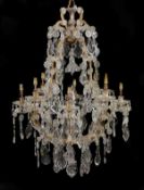 A gilt metal, moulded and cut glass adorned eight light chandelier in Louis XV style, early 20th