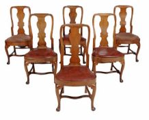 A set of twelve walnut dining chairs in George II style, 19th century, each with double arched back