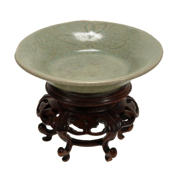 A celadon shallow bowl, Ming, with rounded sides and flared rim covered in a crackled glaze, 15.