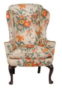 A mahogany and upholstered wing armchair, circa 1750 and later, on shell carved cabriole legs with