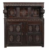 A Charles II oak court cupboard, circa 1670, the upper section with a relief carved frieze of