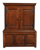 A George I or George II oak cupboard, circa 1730, with moulded cornice above twin panel doors, the