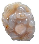 An agate carving of Budai, the portly deity sits against a stand of bamboo and holds a pearl in one