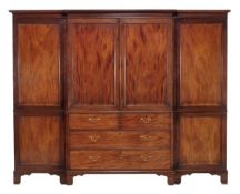 A George III mahogany triple section wardrobe, circa 1780, with central linen press flanked by