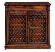 A late Regency rosewood side cabinet circa 1820 with a rectangular top, a frieze flanked by carved