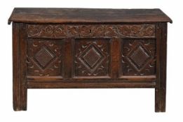 A Charles II oak coffer, circa 1670, with hinged top, the front with three recessed panels carved