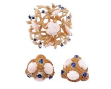 A pair of coral and sapphire ear clips, the textured triangular panels set with three claw set oval