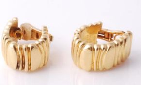A pair of ear clips by Cartier, the polished and reeded hoops, stamped Cartier 750, 1992, and