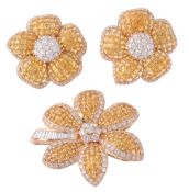 A yellow sapphire and diamond brooch and ear clips suite, the brooch composed as a flower head set