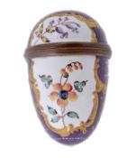 A Bilston enamel nutmeg grater, circa 1770, of egg form, with two white panels of flowers, the