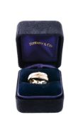 A diamond ring by Tiffany & Co., the double band accented with brilliant cut diamonds,
