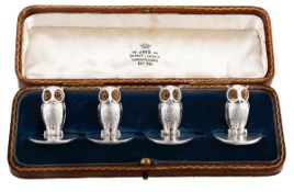 A set of four Edwardian silver owl menu card holders by The Goldsmiths & Silversmiths Co. Ltd,