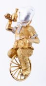 A cultured pearl and diamond unicyclist brooch, the figure holding a tray whilst riding a unicycle
