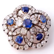 A sapphire and diamond flowerhead brooch, centered with a cushion cut sapphire within a surround of