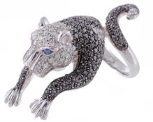 A diamond and black diamond panther ring by Currado, the pouncing panther set throughout with
