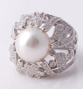 A cultured pearl and diamond dress ring, the cultured pearl within a pierced diamond foliate
