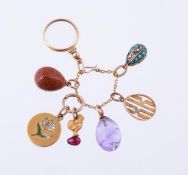 A collection of Russian miniature egg and charm pendants, including a polished amethyst egg,