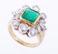 An emerald and diamond cluster ring, the rectangular step cut emerald in a collet setting within a