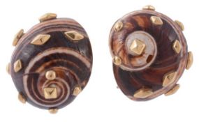 A pair of natural shell ear clips by Trianon, the natural shelss each applied with gold stud