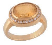 A citrine and diamond ring by Kiki McDonough, the oval shaped citrine in a collet setting, within a