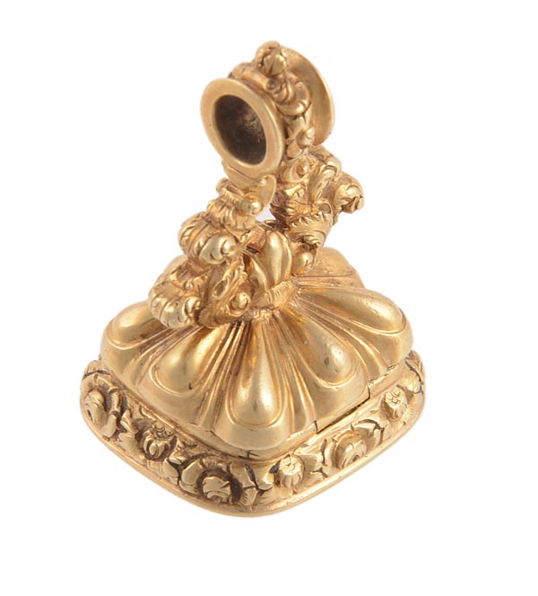 A mid 19th century gold fob seal, chased with flowers, the bridge chased with scrolls, opening to