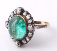 A Georgian emerald and diamond ring, circa 1820, the central oval cabochon emerald within a