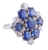 A sapphire and diamond ring, the panel set with seven oval shaped sapphires, accented with old