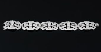 A diamond panel bracelet, the geometric pierced panels set with eight cut diamonds, each centred