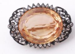 An early 19th century golden topaz and diamond brooch, circa 1830, the oval cut topaz within a