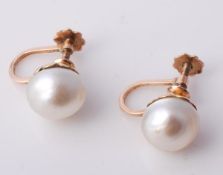 A pair of natural pearl earrings, the pearls measuring 9.6mm with screw back fittings. Offered for