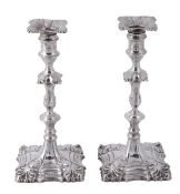 A pair of late George II cast silver candlesticks by William Cafe, London 1759, shaped square with