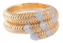 A diamond set bangle, the sprung bangle with pave set diamond and polished chevron links,