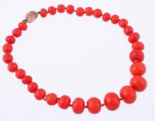A graduated single strand coral necklace, composed of thirty two polished coral (corallium rubrum)