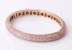 A pink diamond bangle by Graff, the hinged bangle set throughout with circular shaped pink