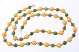 A nephrite and decorative bead necklace, the polished nephrite beads interspaced with gold coloured