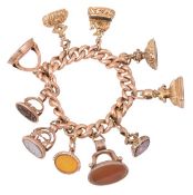 A gold curb link bracelet suspending ten fob seals, including a fob seal of a cherub riding a