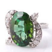 A diamond and green tourmaline dress ring, the oval cut tourmaline between two brilliant cut