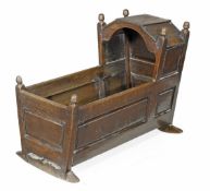 An oak child`s crib, first half 18th century, turned finials, panelled sides, 71cm high, 99cm long,