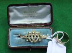A late Victorian gold and half-pearl brooch, (one pearl missing), with an open design of twin