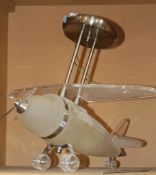 A perspex hanging light in the form of an aeroplane, of recent manufacture, 41cm high, 51cm wide,