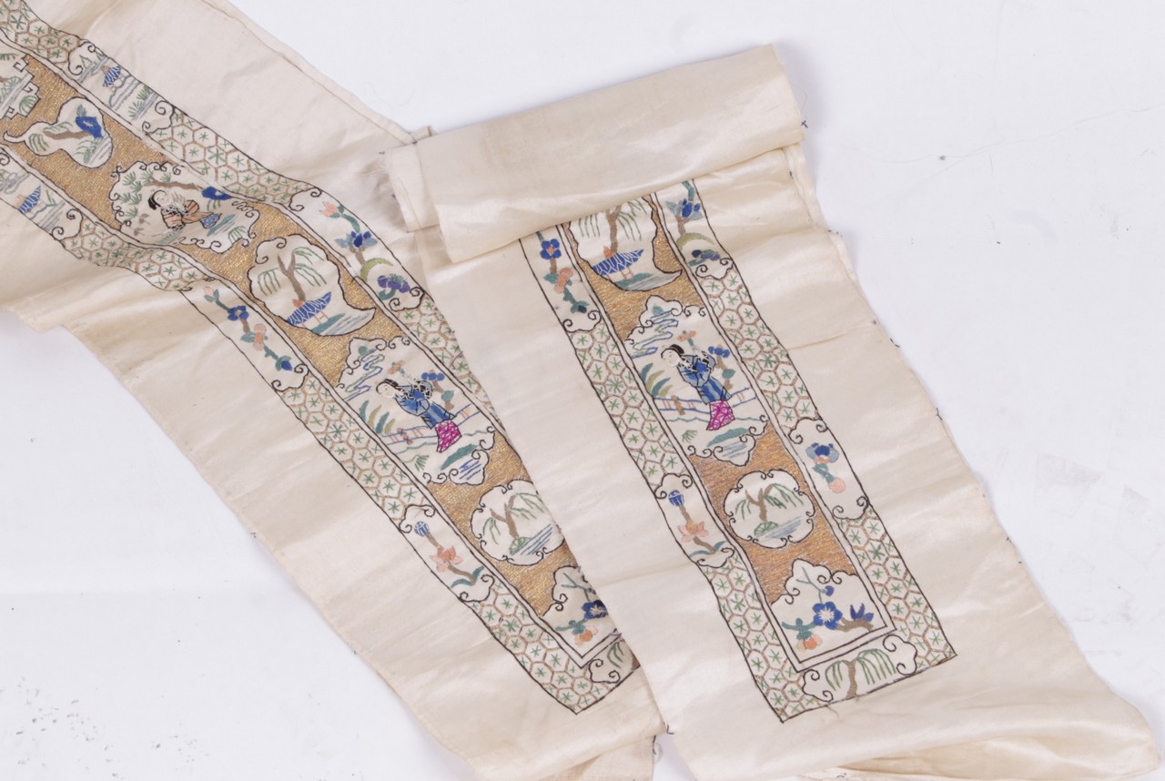 A pair of Chinese sleeve bands, on ivory silk worked in coloured silks and gold coloured metallic