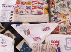 A collection of commemorative textiles, including: three black silk cushion covers decorated with