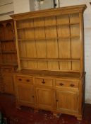 A pine dresser with a three shelf plate rack and drawers and cupboards below