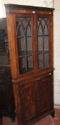 A George III style mahogany floor-standing corner cupboard, the upper section with a pair of glazed