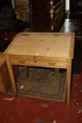 A clerks pine writing desk with lift up slop revealing pigeonholes, fitted a drawer on square